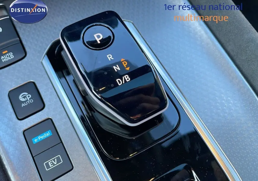 Gros plan sur la console centrale noire brillante avec sélecteur de vitesses électronique du Nissan Qashqai blanc nacré 2025.