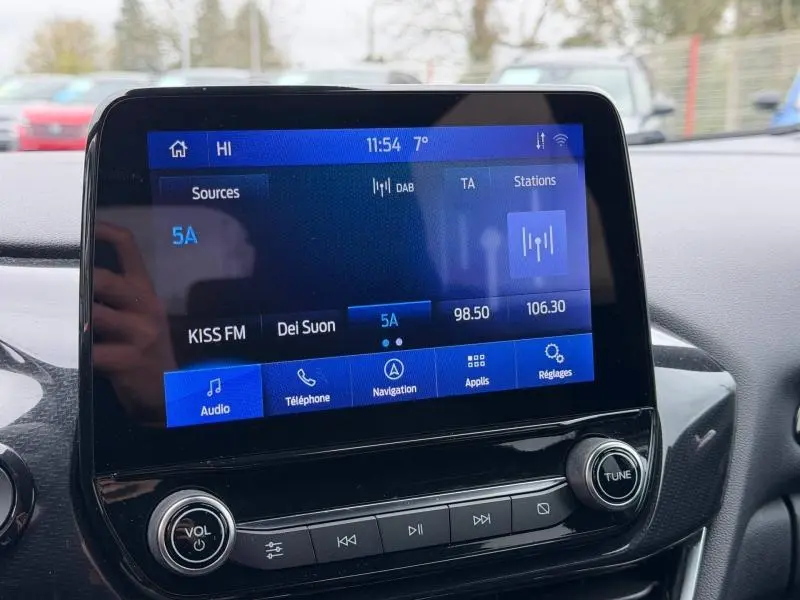 Écran tactile central du Ford Puma 2024 affichant la radio et les options multimédias, avec commandes physiques en dessous.