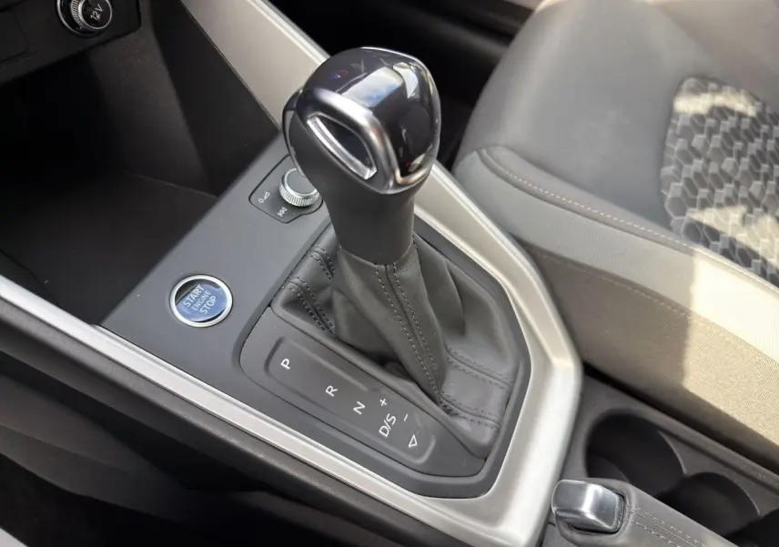 Le levier de vitesses automatique noir et argenté de l'Audi A1 Sportback 2025 vu en gros plan côté console centrale.