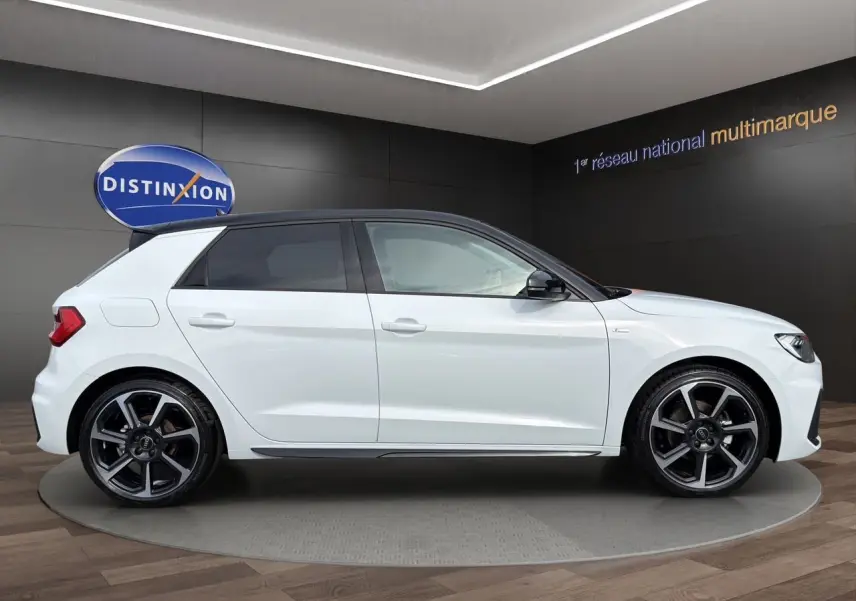Audi A1 Sportback blanc à toit noir en vue profil droit, avec jantes 18 pouces bicolores et vitres arrière surteintées.