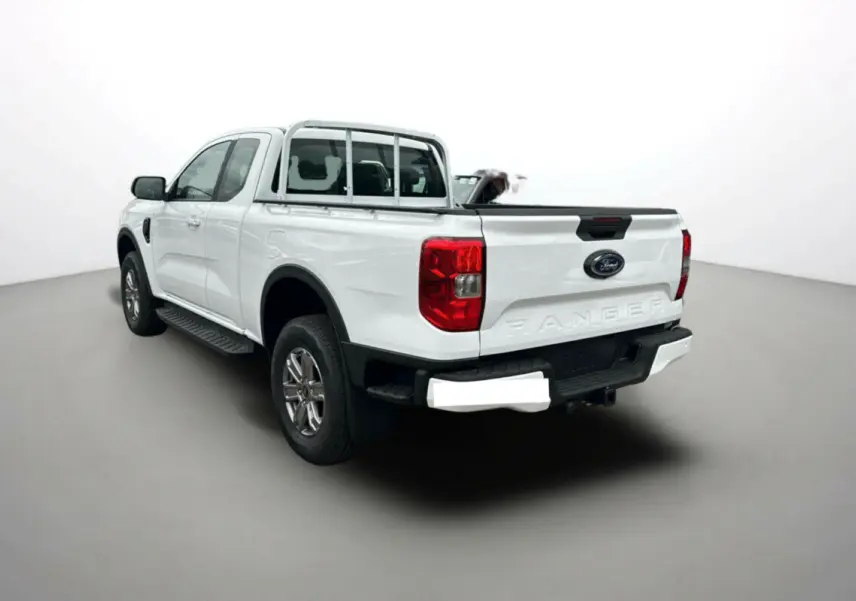 Ford Ranger blanc glacier en 3/4 arrière droit, avec benne ouverte et marchepieds latéraux visibles.