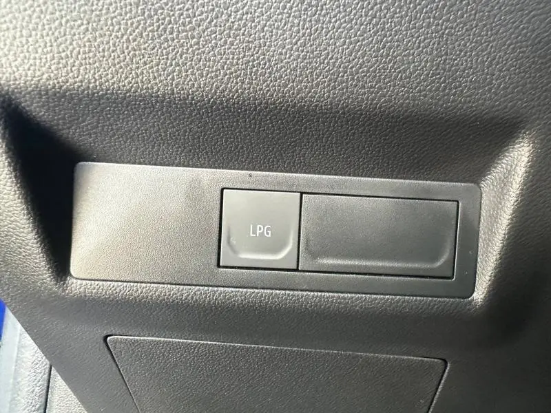 Détail intérieur du bouton LPG sur tableau de bord noir du Renault Captur 2025 Bleu Iron/Noir Etoilé.