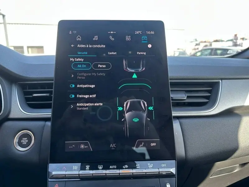 Vue intérieure centrée sur l'écran tactile du tableau de bord du Renault Captur 2025, affichant les aides à la conduite.