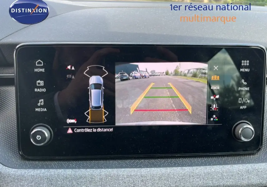 Écran multimédia affichant la caméra de recul et l’alerte de distance du Skoda Scala gris magnétique, vue intérieure tableau de bord.