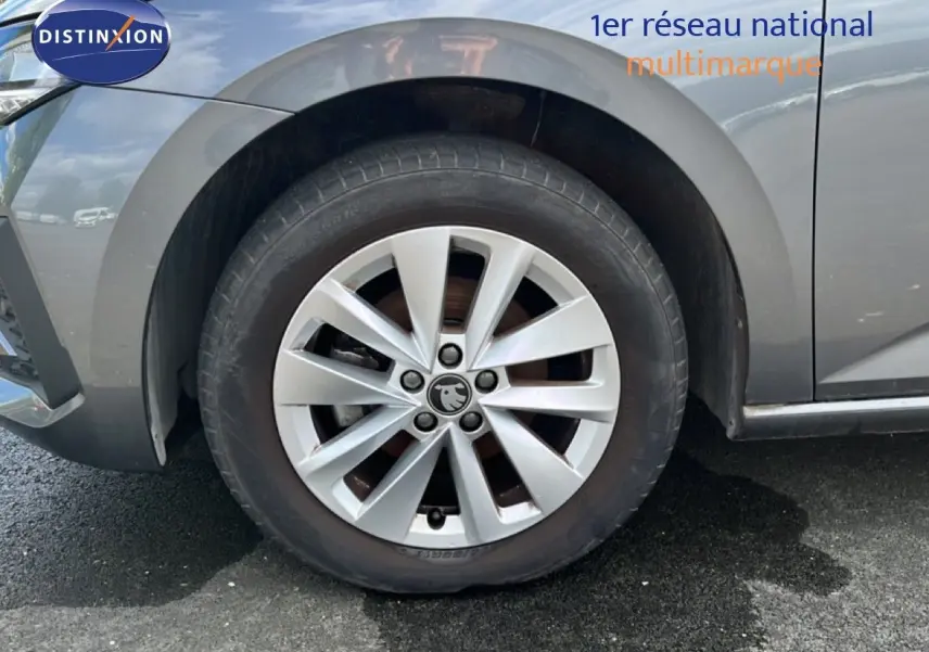 Gros plan sur la roue avant gauche d'une Skoda Scala gris magnétique métal avec jante alliage 16 pouces.