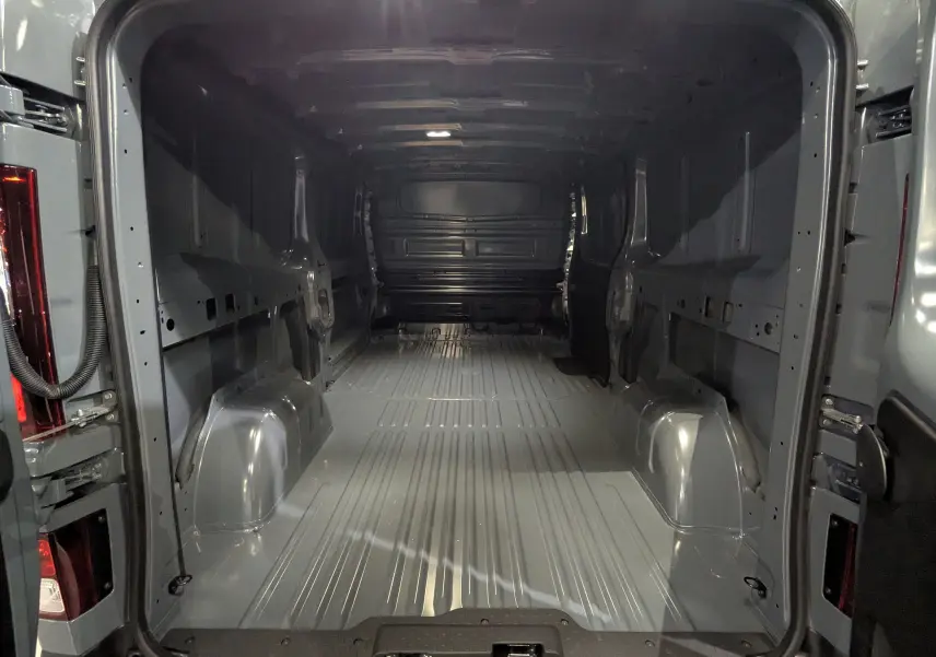Vue intérieure arrière du Renault Trafic Fourgon L2H1 2025 gris urbain, montrant la grande capacité de chargement vide.
