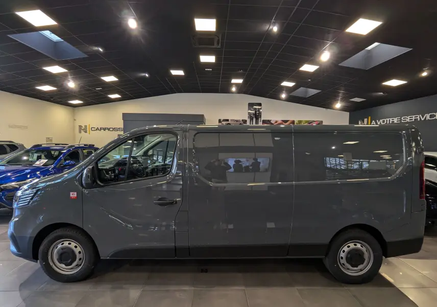 Profil côté gauche du Renault Trafic Fourgon L2H1 2025 en gris urbain, avec jantes acier et vitres teintées.