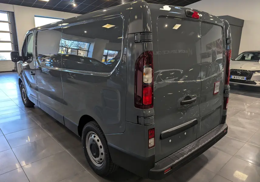 Vue 3/4 arrière droite du Renault Trafic Fourgon L2H1 2025 en gris urbain, avec portes arrière fermées en showroom.