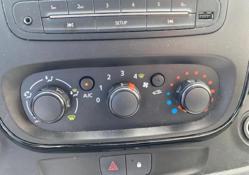 Gros plan sur les commandes de climatisation et audio du tableau de bord d'un Opel Vivaro blanc de 2018.