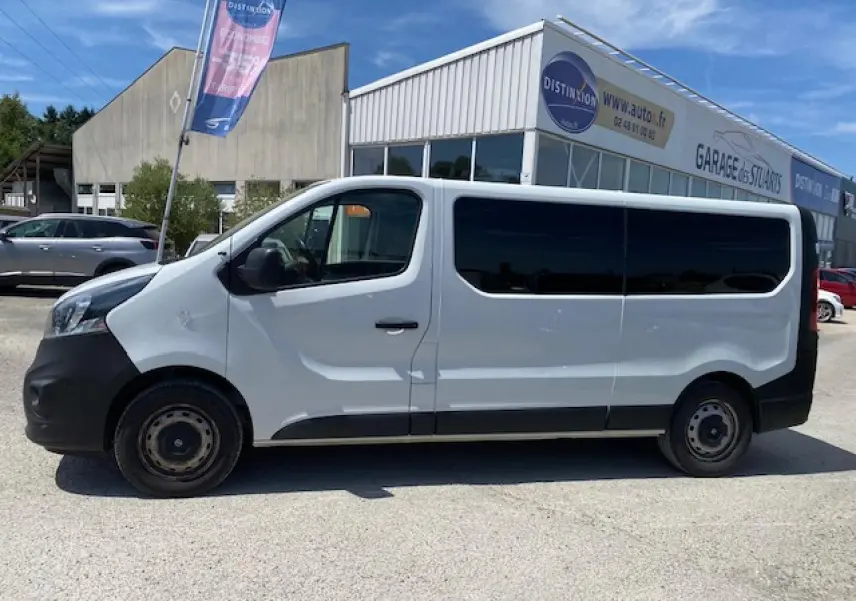 Profil droit d'un Opel Vivaro blanc 2018, version 9 places, avec vitres arrière teintées et pare-chocs noirs.