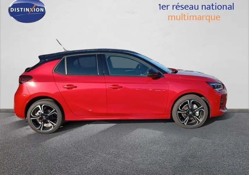 Profil côté gauche d'une Opel Corsa 2023 rouge Kardio métal avec toit noir et jantes alliage noires.
