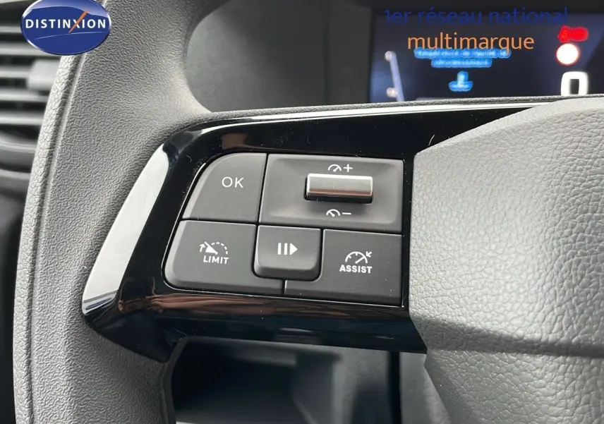 Gros plan sur les commandes au volant du Peugeot Expert Fourgon blanc, version 2025, avec boutons de régulateur et limiteur.