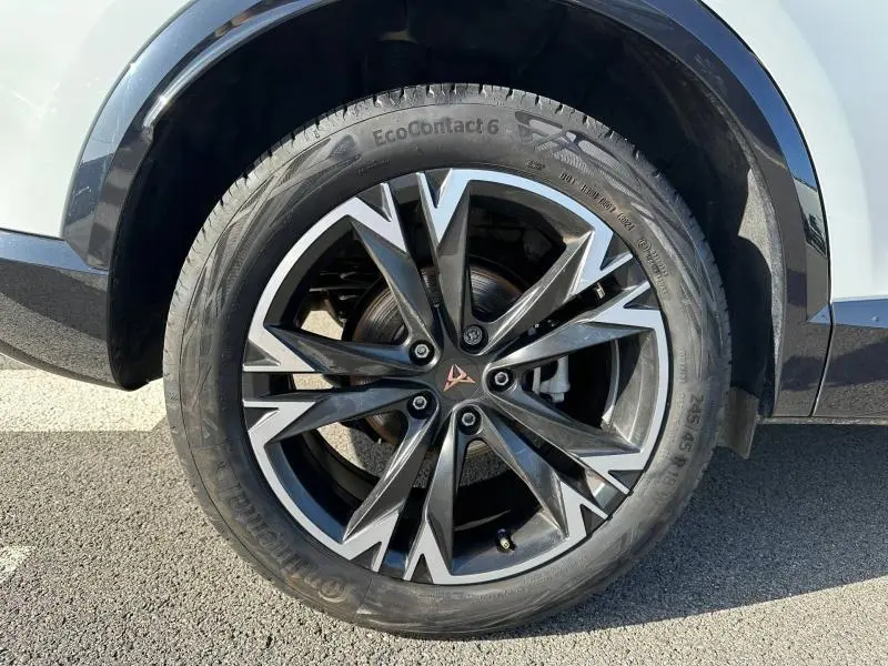 Gros plan sur la roue avant droite du CUPRA Formentor blanc Nevada, avec jante alliage noire et argentée au design anguleux.