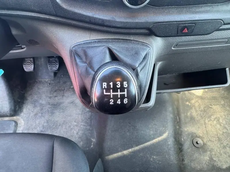 Le levier de vitesses manuel noir du Ford Transit Fourgon T350 blanc, vu de dessus dans l'habitacle avant.