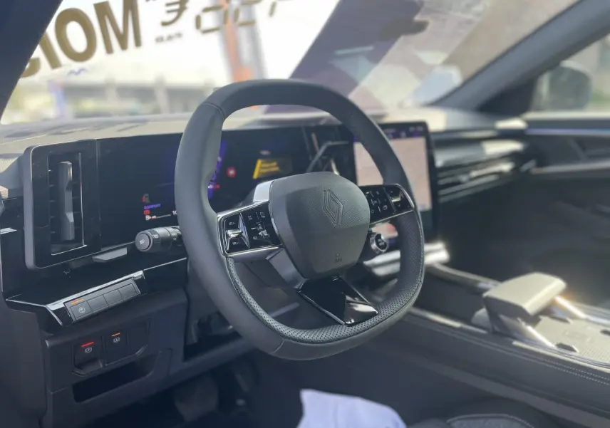 Intérieur Renault Rafale 2025, vue du volant en textile refined avec tableau de bord numérique et écran tactile central.