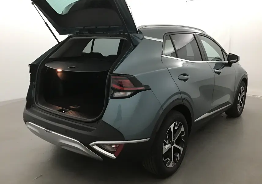KIA SPORTAGE gris Sirius vu de l'arrière côté droit avec coffre ouvert et feux arrière LED allumés.
