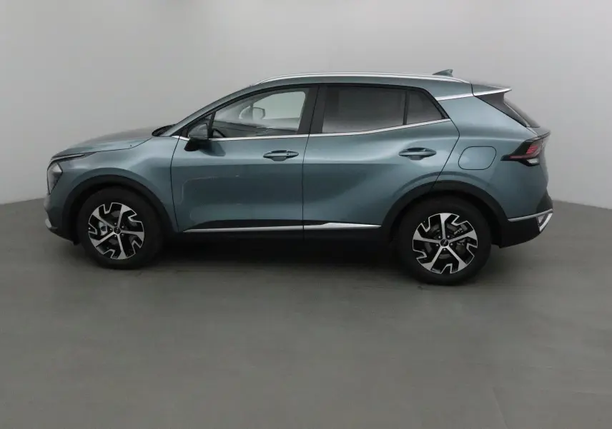 Profil côté gauche du Kia Sportage gris Sirius 2025 avec jantes alliage noires et design moderne.