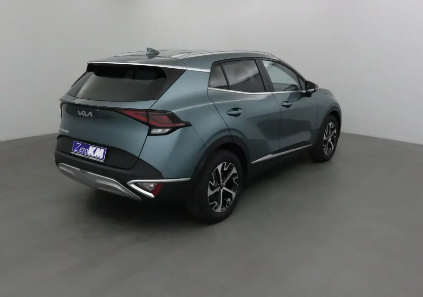 Vue 3/4 arrière droite du Kia Sportage gris Sirius 2025 avec jantes alliage et feux LED distinctifs.