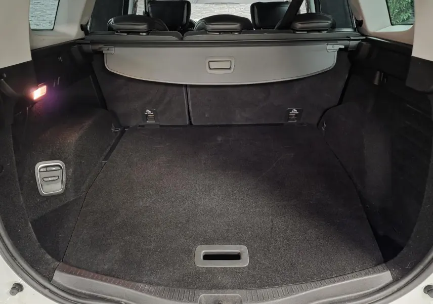 Coffre spacieux du Renault Scénic blanc 2017, vue arrière ouverte avec cache-bagages et éclairage intérieur.