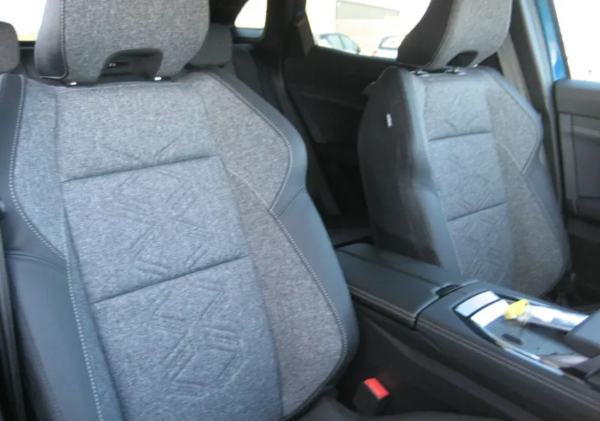 Gros plan sur les sièges avant gris tissu et cuir du Renault Austral PH.2, avec console centrale visible entre eux.