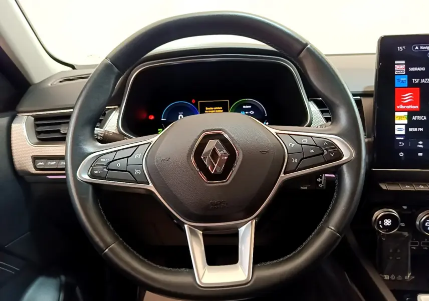 Vue rapprochée du volant cuir noir de la Renault Arkana Techno E-Tech 2023 avec tableau de bord numérique et écran tactile.
