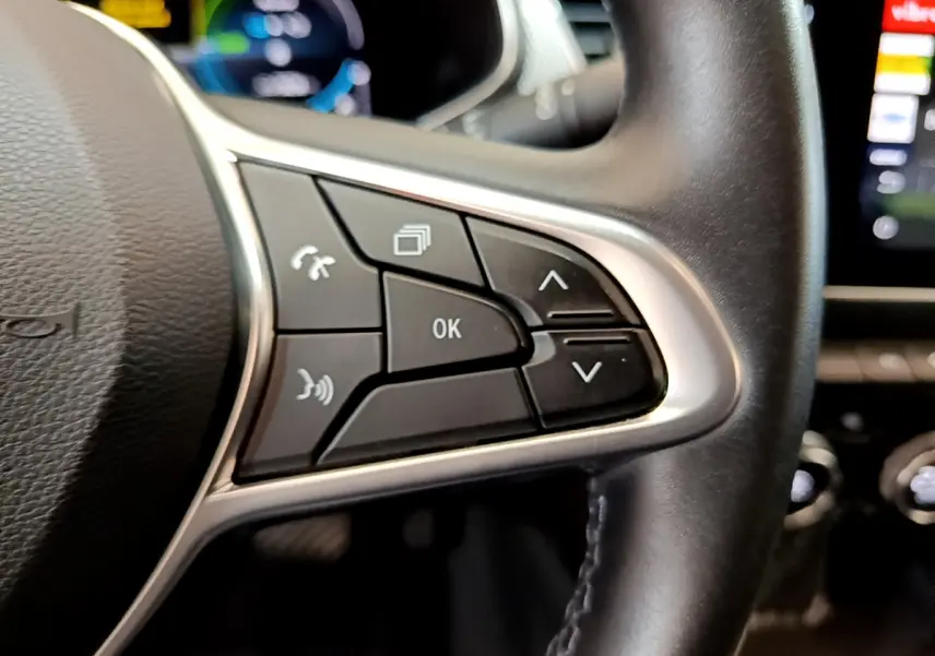 Gros plan sur les commandes multifonctions côté droit du volant cuir du Renault Arkana bleu hybride 2023.
