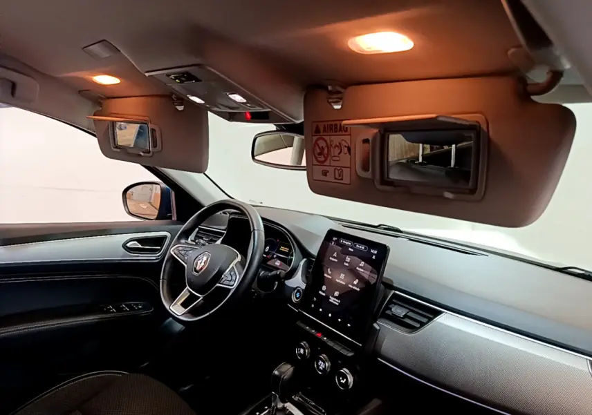 Intérieur noir du Renault Arkana bleu, vue côté conducteur, tableau de bord avec écran tactile vertical et volant multifonctions.