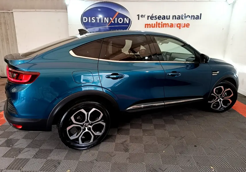 Renault Arkana Techno E-Tech hybride bleu en vue profil côté gauche, soulignant ses lignes fluides et jantes distinctives.