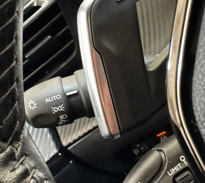 Gros plan sur les commandes au volant du Peugeot 2008 gris foncé, avec palettes de changement de vitesse et commandes de régulateur.