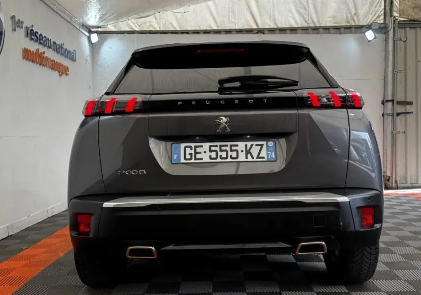 Vue arrière d’un Peugeot 2008 gris foncé 2022 avec feux LED et double sortie d’échappement rectangulaire.