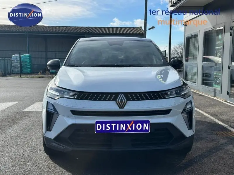 Vue avant d'un Renault Captur blanc nacré avec toit noir, mettant en valeur sa calandre moderne et ses phares LED fins.