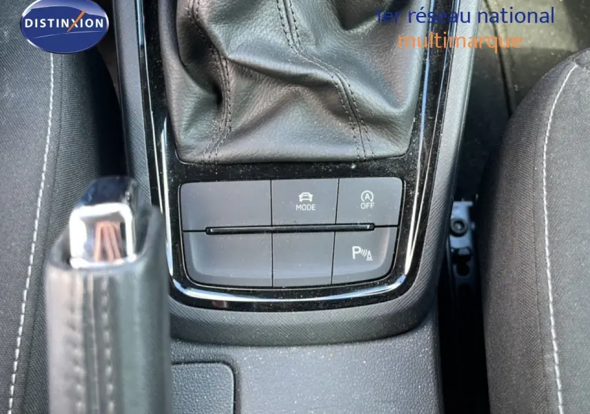 Vue rapprochée de la console centrale avec levier de vitesses et boutons de contrôle sur tissu gris noir intérieur Skoda Scala 2025.