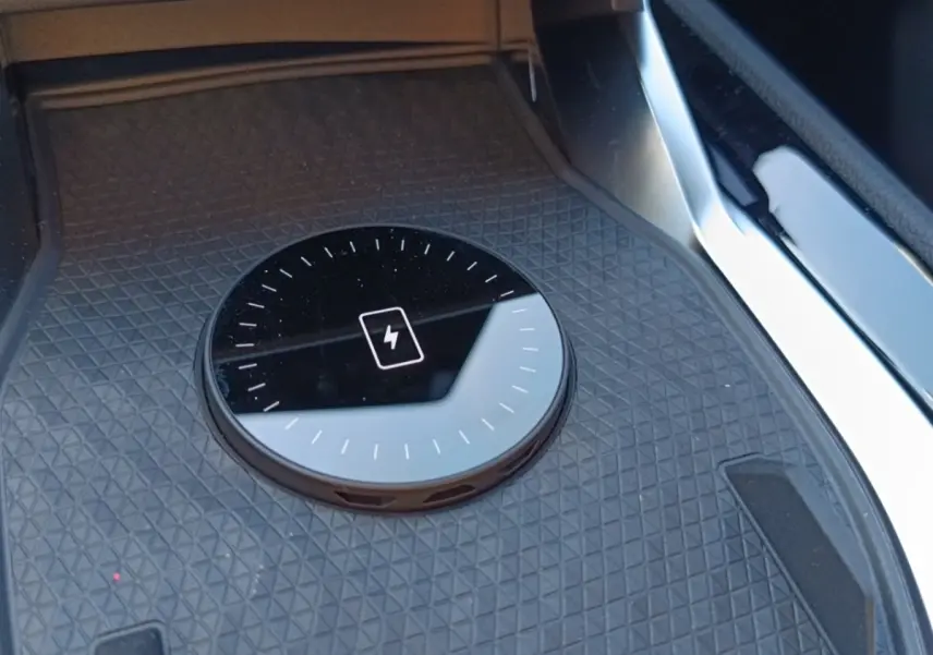 Gros plan sur la zone de recharge par induction noire dans l'habitacle du Renault Austral blanc esprit Alpine.