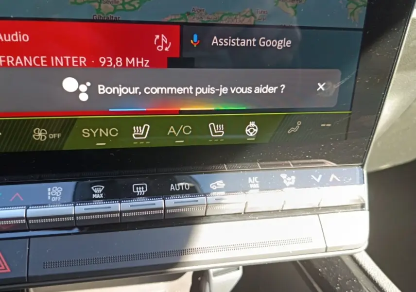 Gros plan sur l'écran tactile central du tableau de bord du Renault Austral blanc, affichant l'assistant Google.