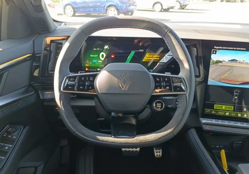 Vue intérieure centrée sur le volant suédé et cuir du Renault Austral esprit Alpine, avec tableau de bord digital et écran tactile.