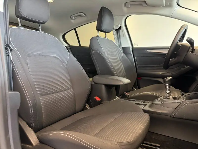 Vue intérieure avant de la Ford Focus 1.0 Flexifuel Titanium X Business, sièges tissu noir et levier de vitesse manuel visible.