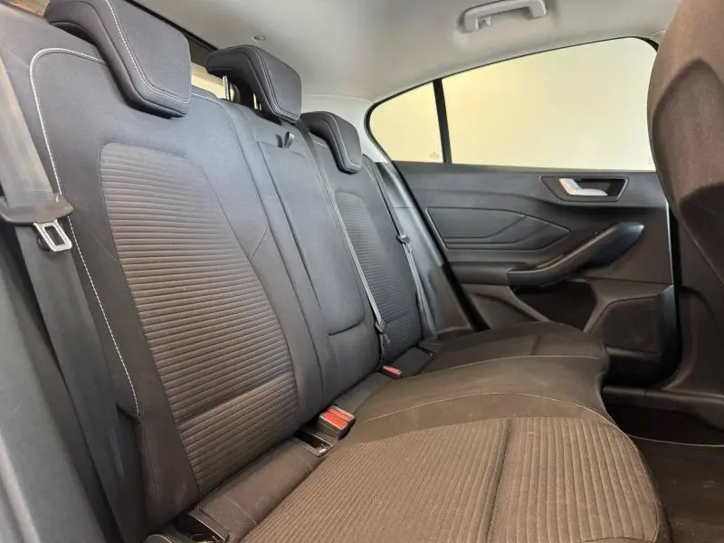 Vue latérale intérieure des sièges arrière noirs de la Ford Focus 2021 avec ceintures et appuie-têtes visibles.