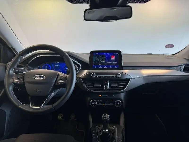 Intérieur de Ford Focus 2021 vue tableau de bord, volant cuir multifonction et écran tactile central allumé.