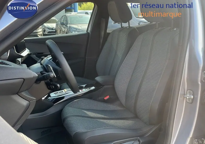 Vue intérieure côté conducteur du Peugeot 2008 Hybrid gris Artense, mettant en valeur les sièges tissu et cuir noir.
