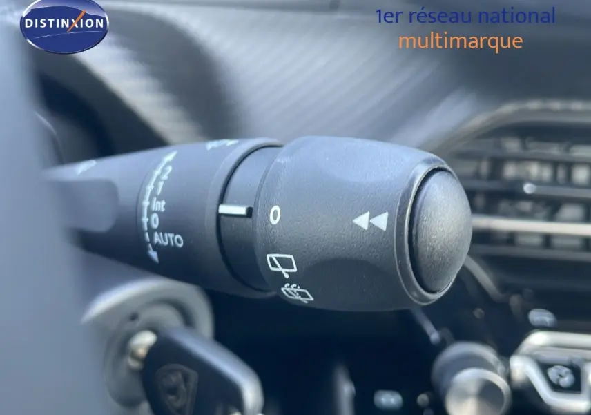 Gros plan sur la commande d'essuie-glace du Peugeot 2008 gris Artense, montrant les réglages au tableau de bord.