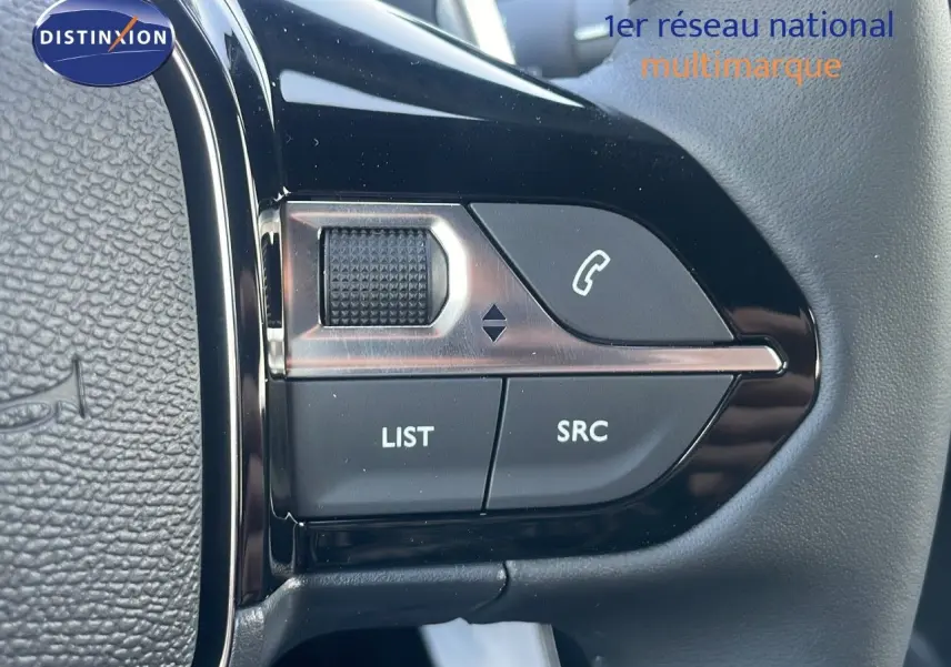 Gros plan sur les commandes au volant noir du Peugeot 2008 Hybrid 136ch Allure 2025, finition cuir noir.