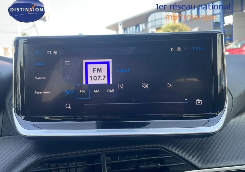 Écran tactile central du tableau de bord du Peugeot 2008 Hybrid 136ch Allure gris, affichant la radio FM 107.7