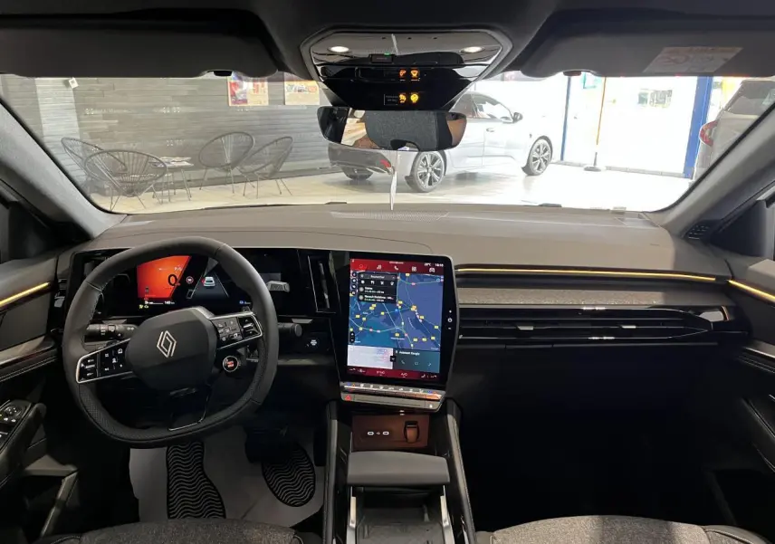 Vue intérieure frontale du tableau de bord de la Renault Rafale blanche avec écran tactile vertical et volant multifonction.