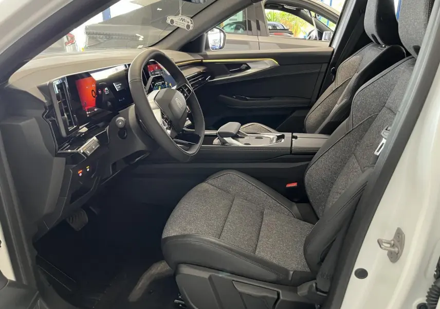 Intérieur côté conducteur de la Renault Rafale blanche 2025, sièges gris textile et tableau de bord numérique.