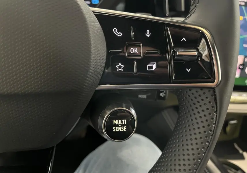 Gros plan sur le volant perforé avec commandes intégrées et bouton Multi-Sense du Renault Rafale blanc 2025.