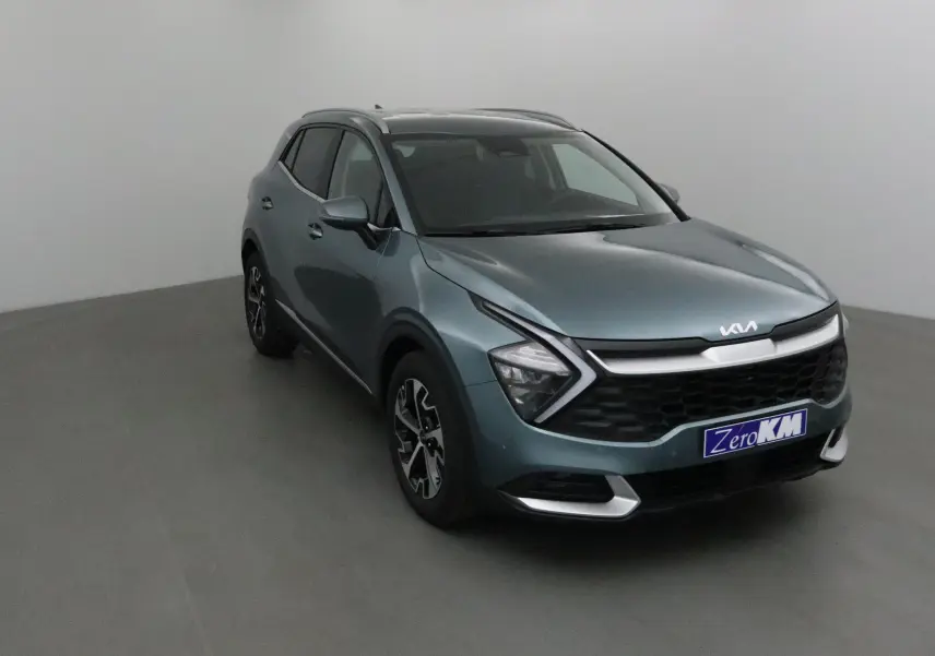 KIA Sportage gris Sirius en 3/4 avant droit, avec calandre noire et feux LED en forme de flèche.