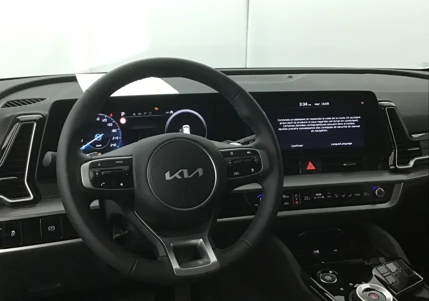 Intérieur du Kia Sportage 2025 montrant le volant cuir et l'écran digital 12,3 pouces du tableau de bord.