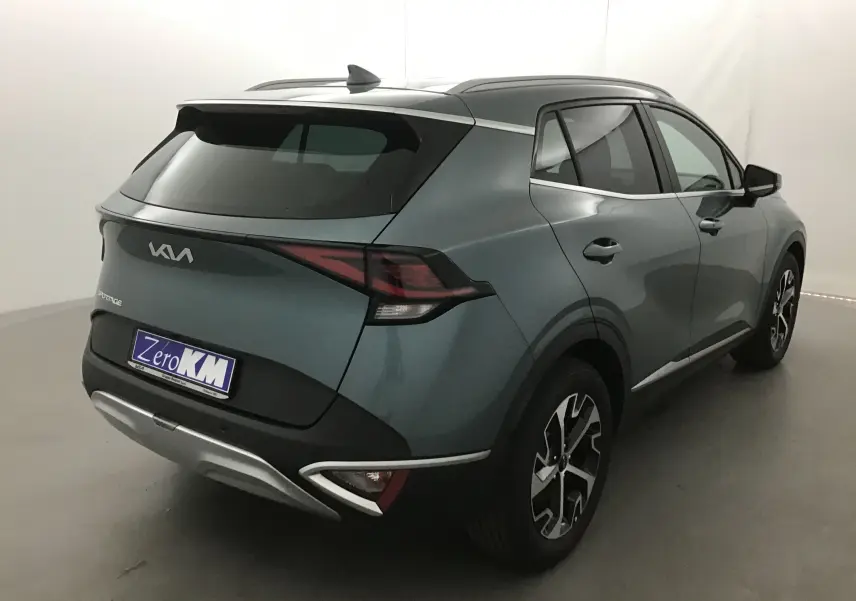 Vue 3/4 arrière droite d'un KIA SPORTAGE gris Sirius 2025 avec jantes alliage et feux arrière LED distinctifs.