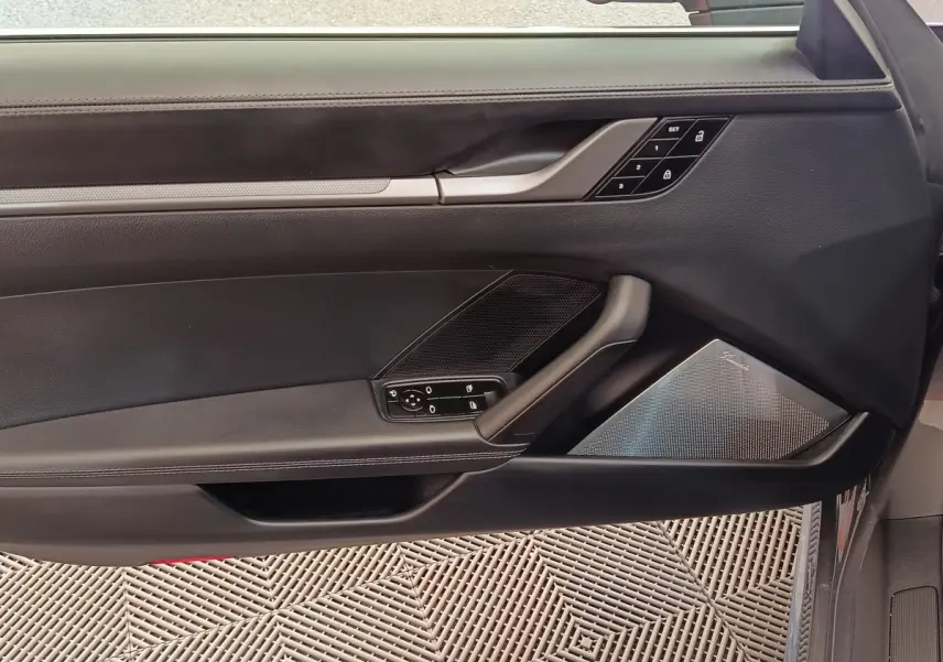 Vue intérieure de la porte côté conducteur d'une Porsche 911 Carrera 4S 2019, garniture cuir noir et haut-parleur Burmester.