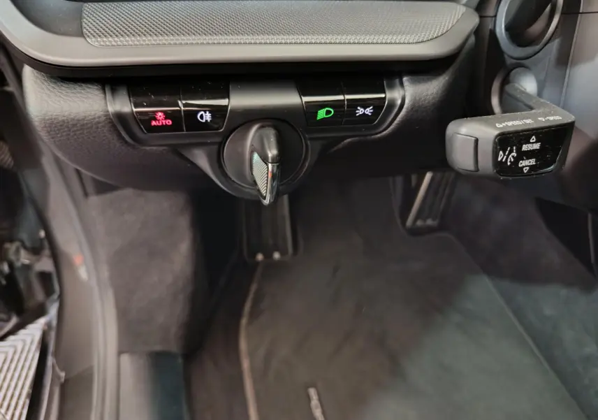 Gros plan sur les commandes d’éclairage et le levier de régulateur de vitesse dans l’habitacle noir d’une Porsche 911 Carrera 4S Coupé 2019.